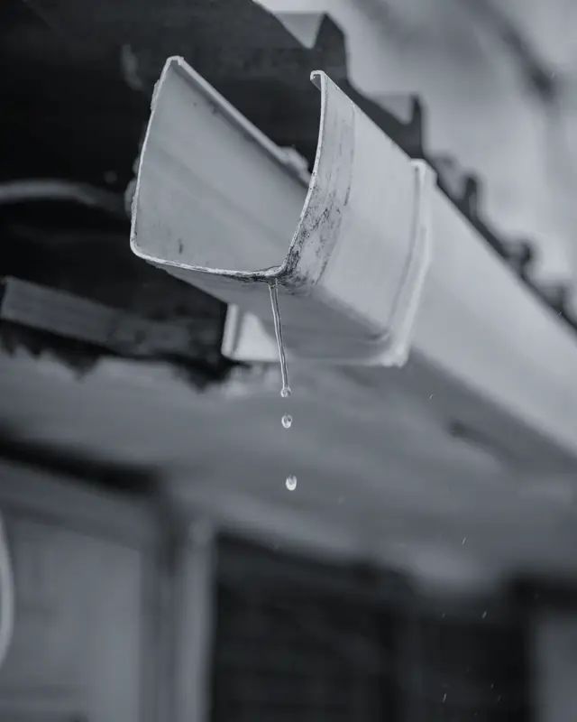Rainwater dripping from a house gutter