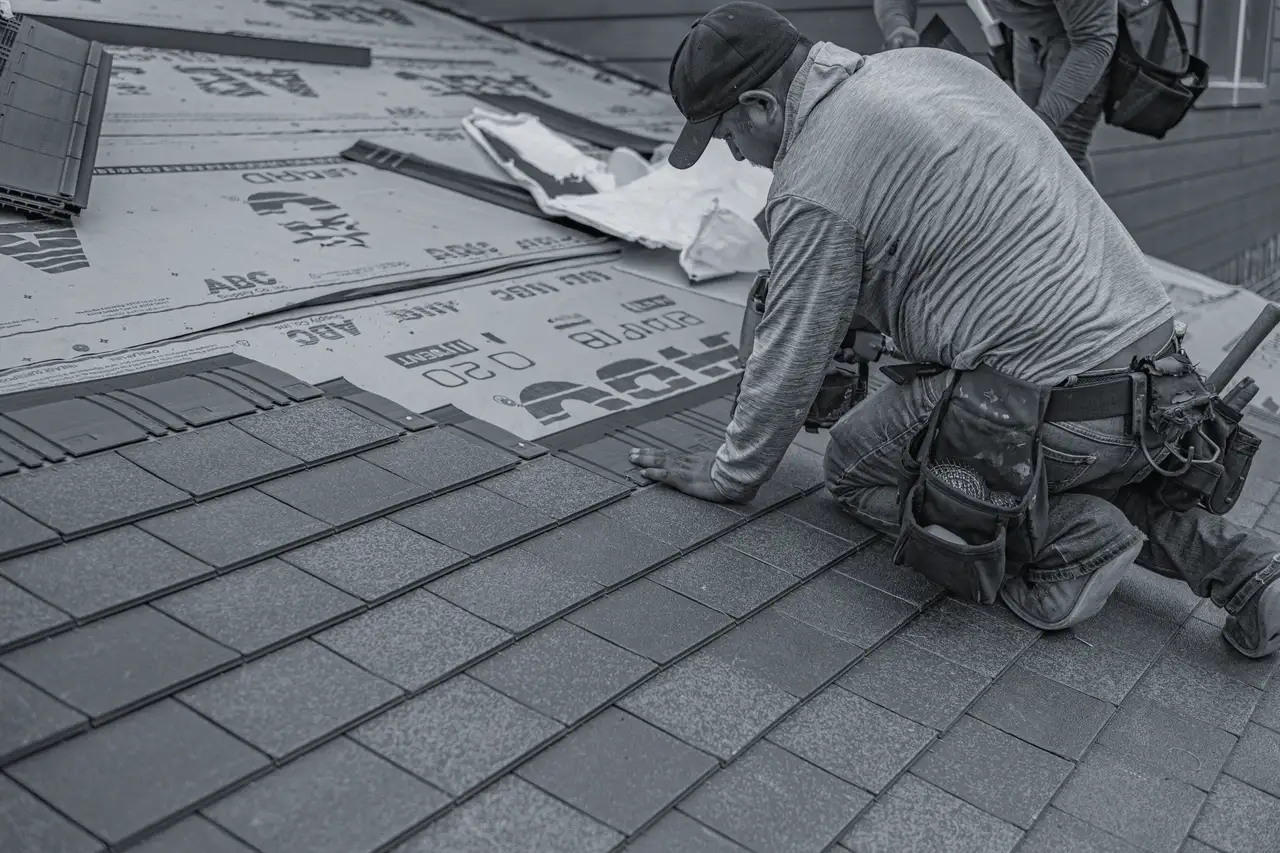 Roofer setting a course of asphalt shingles